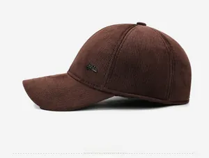 Close-up of brown corduroy winter baseball cap featuring a side fashion metal logo