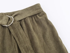 Nahaufnahme der olivgrünen Cordhose mit Gürtel und einer silbernen D-Ring-Metallschnalle