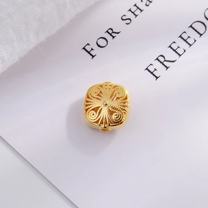 Macro shot of a gold-plated S925 silver hollow bead with intricate floral DIY patterns