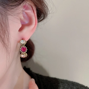 Detailed side view of elegant gold-plated earrings with three vertical colorful crystals