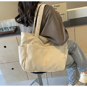 Détail du sac fourre-tout en velours côtelé crème avec texture côtelée et poches