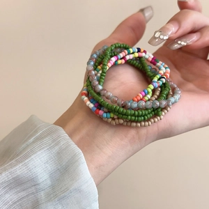 Close-up of colorful Bohemian seed bead bracelets in green, pink and blue tones