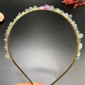 Close-up of handmade golden wire headband wrapped with colorful raw crystal stones