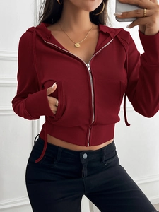 Detail of red ribbed zip-up hoodie featuring a slim cropped fit and front pockets
