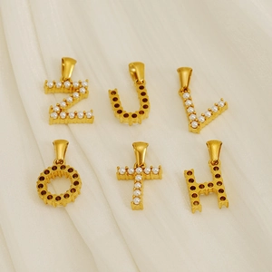 Golden letter pendants Z, U, V, O, T, H with white pearls on elegant white fabric