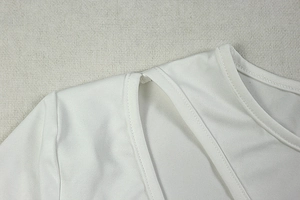 Detail showing white hollow-out neckline and smooth knit fabric texture of the dress