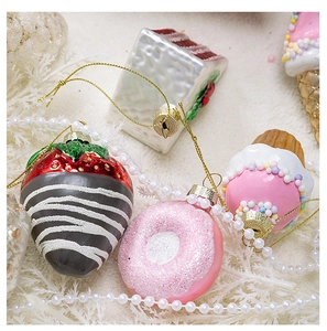 Macro detail of dessert-themed Christmas ornaments with glitter and beads on white fur