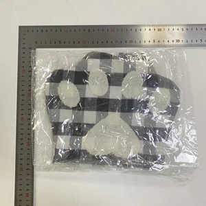 Detail view of plaid dog paw Christmas stocking measuring 28x25cm in packaging