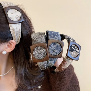 Detail view of paisley fabric headband with a vintage square wood texture side buckle