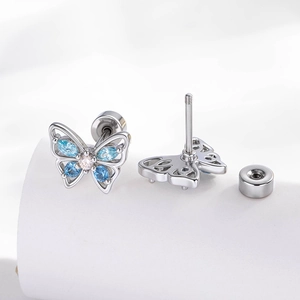 Silver butterfly cartilage studs with blue cubic zirconia on a white display