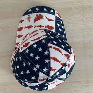 USA flag style baseball cap with stars and red fish print on a light wood background
