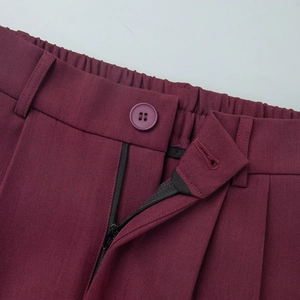 Detail of burgundy suit trousers waist with back elastic band, button and zipper closure