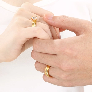 Golden stainless steel couple rings set with four-claw solitaire diamond for wedding