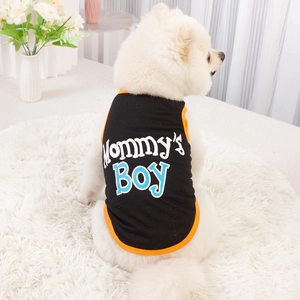 Detail of a black pet vest with orange trim and Mommy's Boy print on a white dog