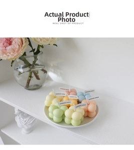 Close-up of colorful bubble cube candles with handmade tags on a white tray