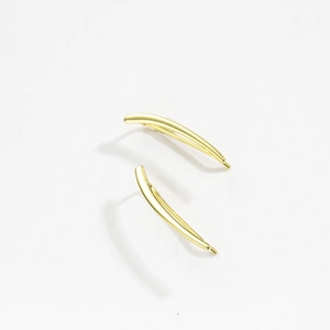 Detail view of gold minimalist curved earrings with polished metallic luster on white background