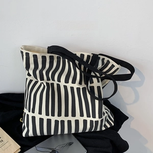 Close-up of minimalist black and white striped canvas tote bag with shoulder straps