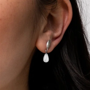 Close-up of elegant teardrop pearl drop earrings in silver finish worn by a model