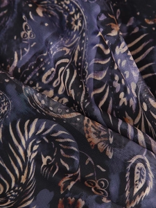 Vue détaillée du tissu en maille transparente avec des motifs ethniques paisley colorés