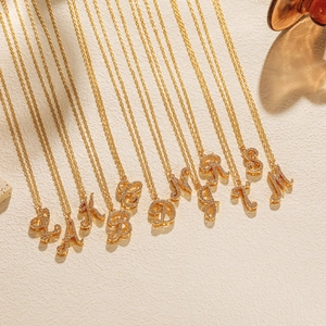Detailed macro view of 18K gold plated letter necklaces with sparkling zircon inlay