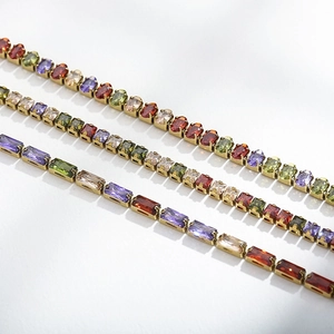 Macro shot of three gold-plated tennis bracelets with multicolored zircon gemstones