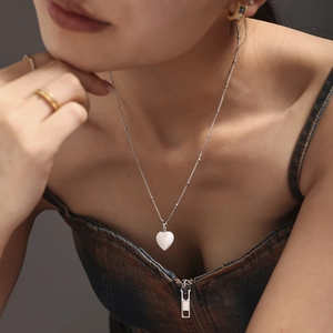 Elegante Halskette mit Herzanhänger aus Muschel und Edelstahl in Silber an einem Model