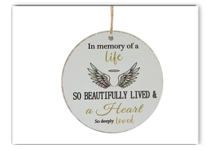 Detail of round wooden Christmas memorial ornament with wings and heartfelt engraving