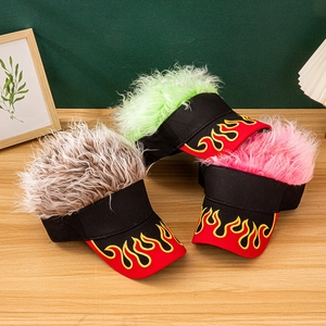 Three visors with colored hair wigs and flame embroidery on a wooden table