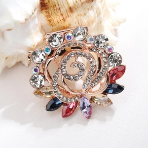 Macro shot of rose gold rose brooch with colorful rhinestones and sparkling crystals