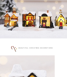 Detail view of four glowing resin Christmas houses with warm LED lights and snowy roofs