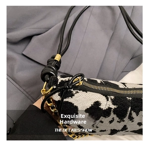 Dettaglio del tessuto jacquard animalier con cerniera dorata e tracolla a catena