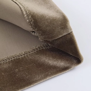 Macro shot of khaki velvet fabric texture and professional overlock stitching detail