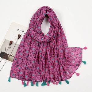 Detail of pink cotton-linen scarf with floral prints and delicate fringe tassel edges