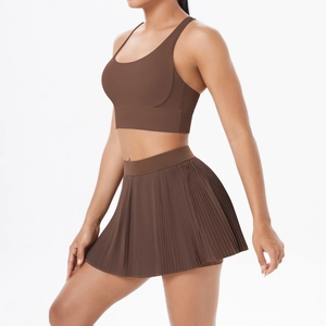 Detail of coffee brown pleated tennis skirt and cross-back sports bra set for fitness