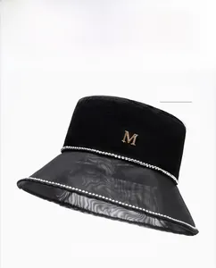 Detail of black satin bucket hat showing mesh brim and silver chain edge trim