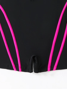 Detail of black sporty swimsuit with pink piping, showing stitching and elastic fabric