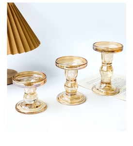 Detailed view of amber glass candle holders in vintage Roman column design with set of three heights