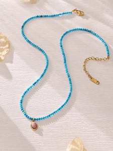 Detailed macro view of turquoise beads and stainless steel clasp with pink stone pendant