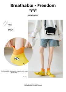 Detail of yellow and orange cotton ankle socks featuring a cute cartoon duck pattern