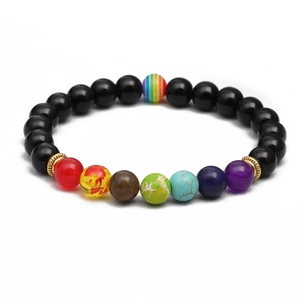 Bracelet chakra en pierres naturelles avec perles noires et séparateurs dorés sur blanc