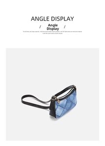 Detail view of denim underarm bag with blue wash fabric, black leather trim and gold zipper