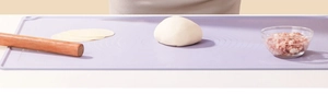 Macro detail of purple silicone baking mat with measurement scales and dough on top