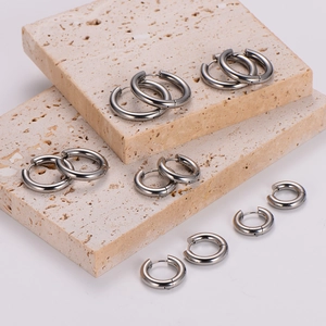 Polished silver stainless steel hoop earrings in various sizes on stone pedestals