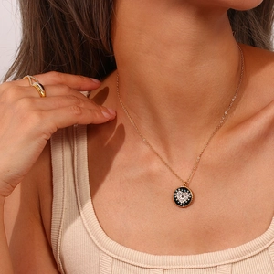 Détail du collier médaille doré avec pendentif cœur en émail sur le cou du mannequin