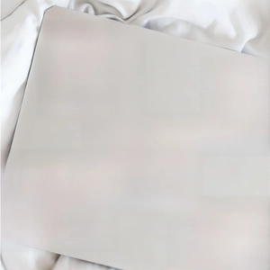 Dettaglio di adesivi vintage con citazioni ispiratrici su laptop in argento