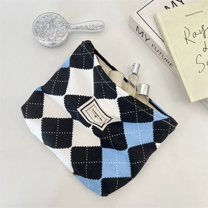 Close-up of checkered makeup bag with 'PLEASANT TIME' label and top zipper closure