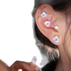 Magnetic stud earrings with white zircons in various sizes worn on ear lobe and cartilage
