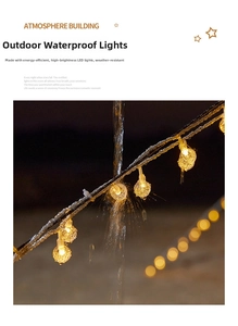 Close-up of warm white LED globe string lights showing waterproof performance under water spray