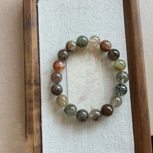 Macro view of natural multi-color rutilated quartz beads on a burlap display pad