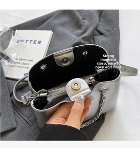 Detail of silver bucket bag showing the secure magnetic closure and leather chain strap